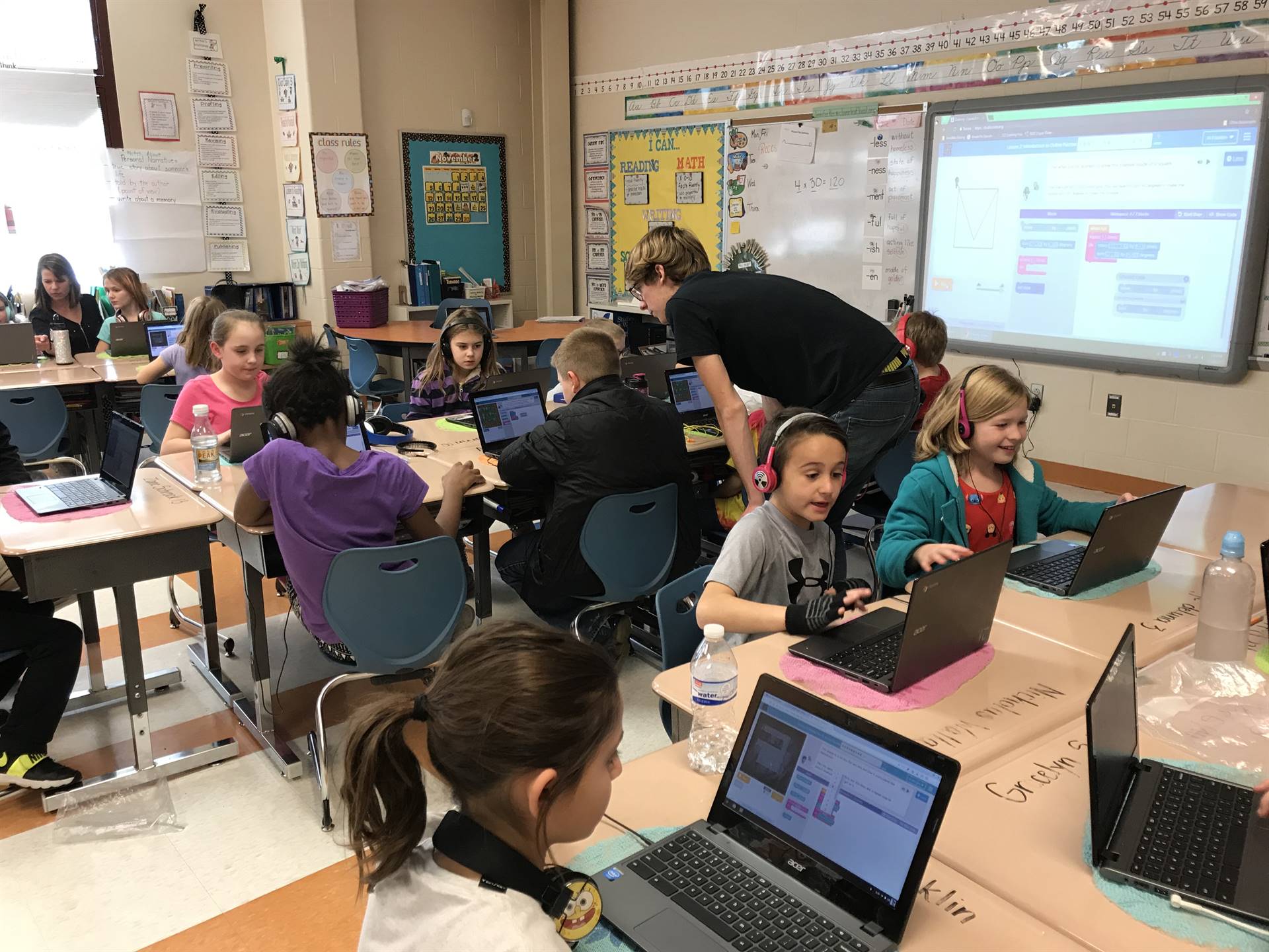 Elementary students work on coding.